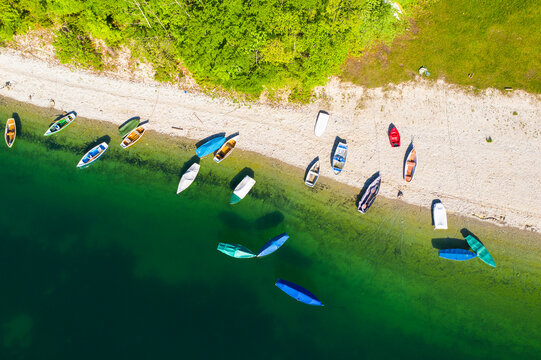 Germany, Bavaria, Lenggries,R owboats left on green shore of Sylvenstein Reservoir