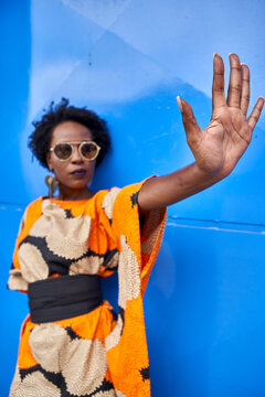 Woman raising her hand in front of blue background