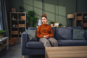 Obraz premium Young woman relaxing on sofa in modern living room