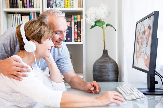 Senior couple at desk having a video conference with their family