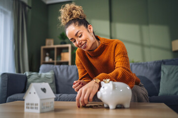 Woman saving money in piggy bank for home ownership