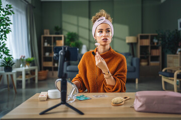 Woman recording beauty tutorial using jade roller for social media © Miljan Živković