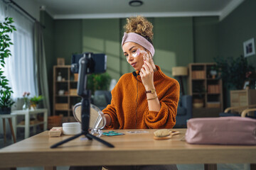 Woman recording beauty tutorial using jade roller for social media © Miljan Živković