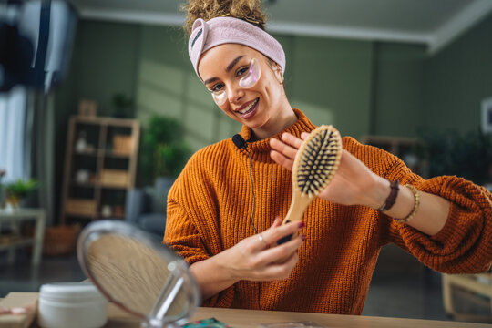 Woman reviewing hairbrush for beauty v-log tutorial