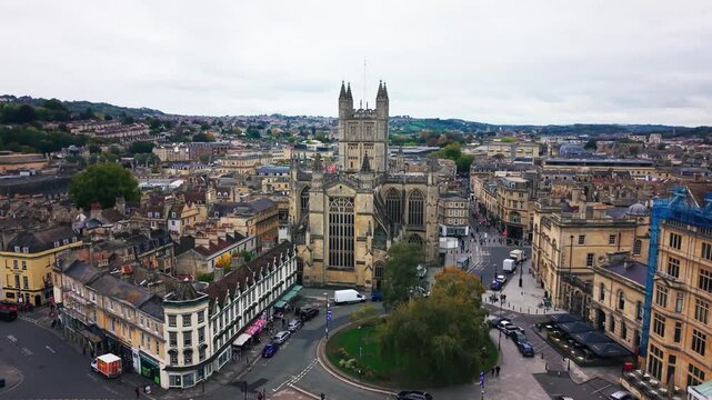 Drone aerial view of Bath Abbey and surrounding Georgian streets in the historic city of Bath Somerset England with cars pedestrians and urban movement