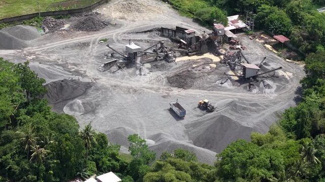 Aerial footage of a stone crushing plant. Producing crushed stone aggregate for construction materials, concrete, and asphalt. Utilizing raw materials from sand mines.