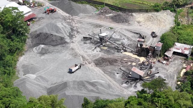 Aerial footage of a stone crushing plant. Producing crushed stone aggregate for construction materials, concrete, and asphalt. Utilizing raw materials from sand mines.