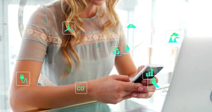 Woman tapping phone scrolling at glass table tracking energy as green icons clustering near laptop