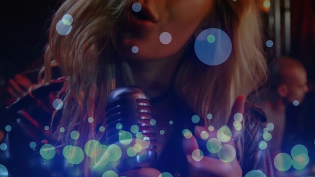 Singer gripping retro chrome mic and starting singing for club, blue bokeh drifting, jacket shining