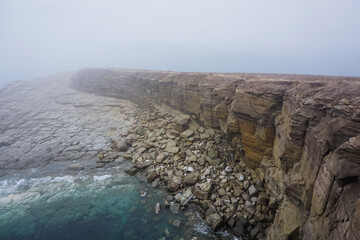 Naklejka premium The rocky and foggy coastline of Russky Island