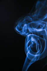 Elegant blue smoke rising against a dark backdrop. The smoke swirls and dances, creating a visually captivating display