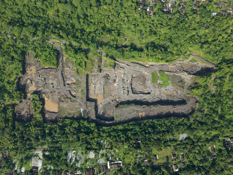 Aerial view of a quarry contrasting sharply with the surrounding dense, vibrant greenery, Klaten Regency, Jawa Tengah, Indonesia.