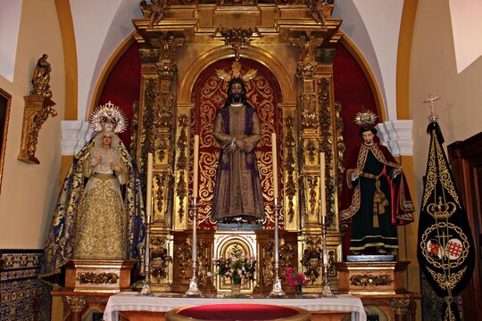 Catholic church altar with religious statues and ornate golden retable, sacred Christian sculptures and devotional figures inside historic Spanish church