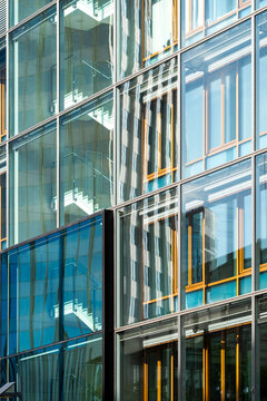 Modern corporate architecture building exterior with glass facade and windows in a colorful pattern creating urban energy and bold design texture