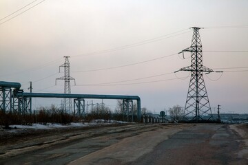 Industrial landscape with power transmission towers and lines. Environmental issues.