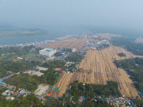 Aerial view of a vast gathering with orderly rows of tents stretching across the landscape near a gleaming white building, Charmonai, Barisal Division, Bangladesh.