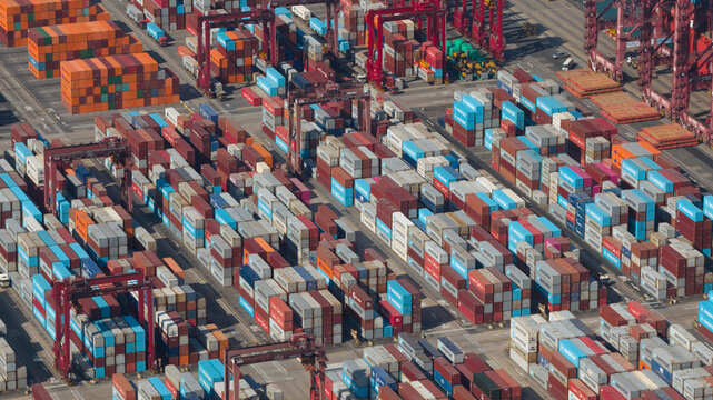 New Territories, Hong Kong - 15 February 2026: Aerial view of a sprawling port facility where stacks of brightly colored shipping containers create a vibrant, geometric tapestry.