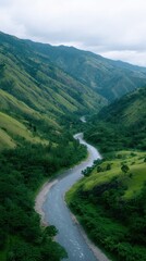 Fototapeta premium Serene Winding River Flowing Through Lush Green Valley Landscape with Mountains