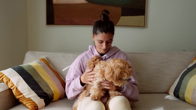 Woman cares pet. Woman nurtures her beloved puppy peacefully inside