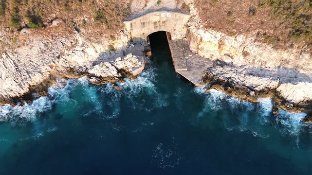 Aerial Top Perspective View Waves Crashing on Rocks near Submarine Bunker in Albania