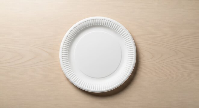 An empty white disposable paper plate rests flat on a plain beige wooden surface, symbolizing simplicity and temporary use, wood, simple, flat