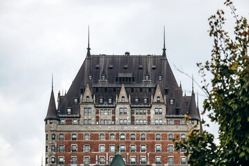 Quebec City, Canada - August 23, 2025: Close-up architectural details of Fairmont Le Chateau Frontenac hotel towers, green copper roofs, turrets and brick stone facade elements © Andrei Antipov
