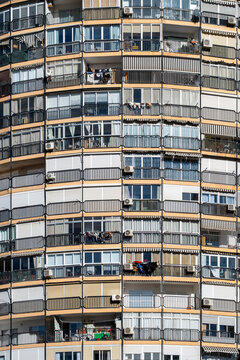 Curved architecture facade with balconies and windows on an apartment residential highrise showing pattern repetition geometry and urban texture in spain