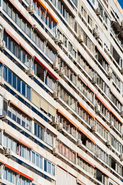 Residential apartment architecture facade packed with balconies and windows forming pattern repetition and strong lines with urban density in spain