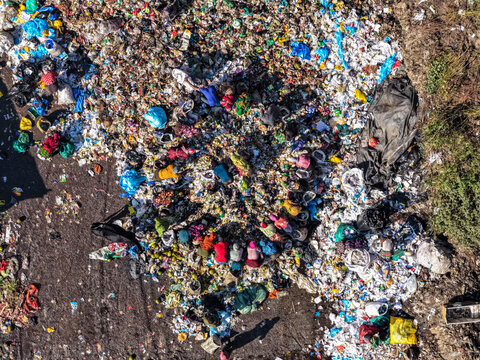 Chattogram, Bangladesh - 25 November 2025: Aerial view of Anondobazar Landfill reveals a mosaic of waste, where figures in vibrant clothing search through the refuse.