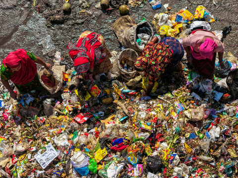 Chattogram, Bangladesh - 25 November 2025: Aerial view of Anondobazar Landfill where women in vibrant sarees are picking through piles of waste, a stark contrast of color and despair.