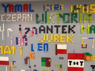 Fototapeta premium Colorful lego word mosaic on gray baseplate