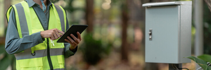 Technician secures electrical cabinet outdoors in field for reliable operation