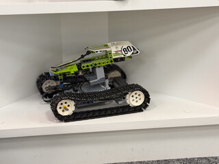 Fototapeta premium Green tracked toy vehicle on shelf