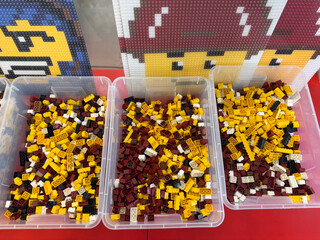 Fototapeta premium Sorted yellow and maroon lego bricks in bins