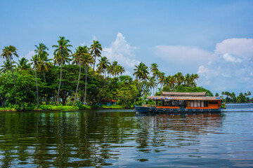 Traditional house boat is anchored on the shores of a fishing lake in Kerala's Backwaters, India. © yotrakbutda