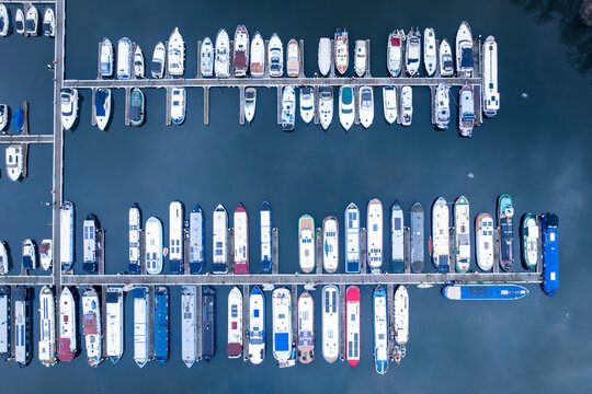 Aerial view of rows of boats docked neatly in the harbor, their colorful hulls reflecting in the tranquil waters, Reading, Berkshire, United Kingdom.
