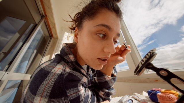 City resident applying mascara outside during morning rush