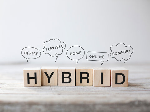 6 small wooden cubes with the word &ldquo;Hybrid&rdquo; written on them. Speech bubbles above them with the words: office, flexible, home, online, comfort