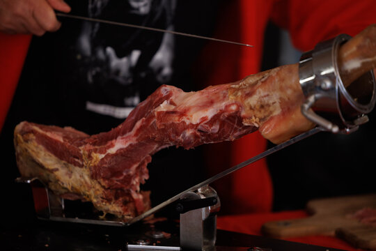 Jambon cru espagnol pos&eacute; sur le jambonnier et le couteau effil&eacute; pour le trancher 