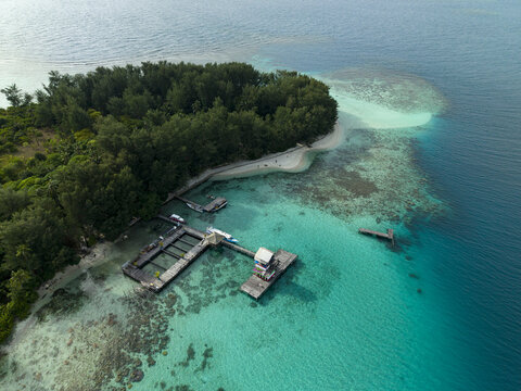 Aerial view of clear turquoise waters meet the lush green island, revealing the Shark Breeding Menjangan Kecil Island, Karimunjawa, Central Java, Indonesia.
