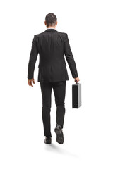 Full length rear view of a businessman in a suit walking and carrying a briefcase