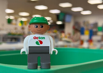 Fototapeta premium Toy figure with octan logo on green surface