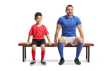 Obraz premium Adult football player and a boy sitting on a bench