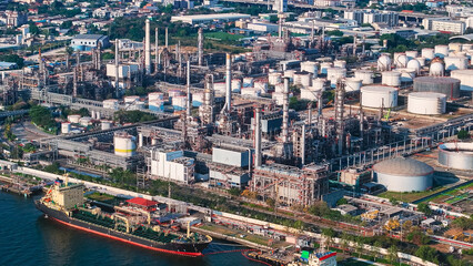 Obraz premium Aerial view of a bustling oil refinery and petroleum terminal with storage tanks and tanker ships at a busy port