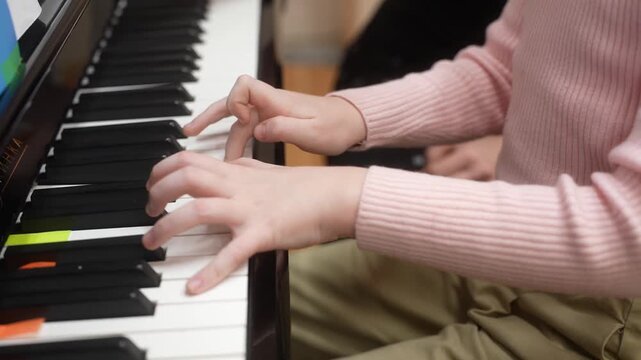Young kid playing piano, closeup. Music school lesson