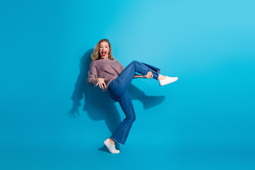 Young stylish woman jumping in blue background fashion lifestyle moment perfect for advertising and...