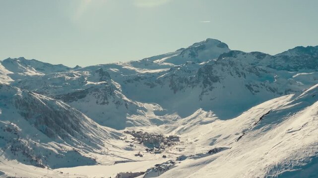 drone footage of france alps ski resort with snow mountains and people skiing