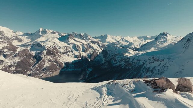drone footage of france alps ski resort with snow mountains and people skiing