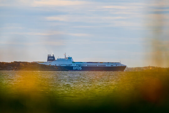 Gothenburg, Sweden - september 29 2024: passenger ferry sailing near coastal cliffs at sunset.