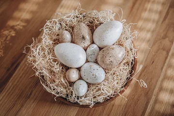 Easter eggs in a nest on a wooden background. Vintage style. © Svetlana